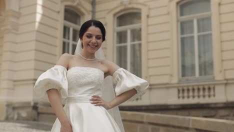 la novia en un vestido de novia blanco sonríe para la cámara