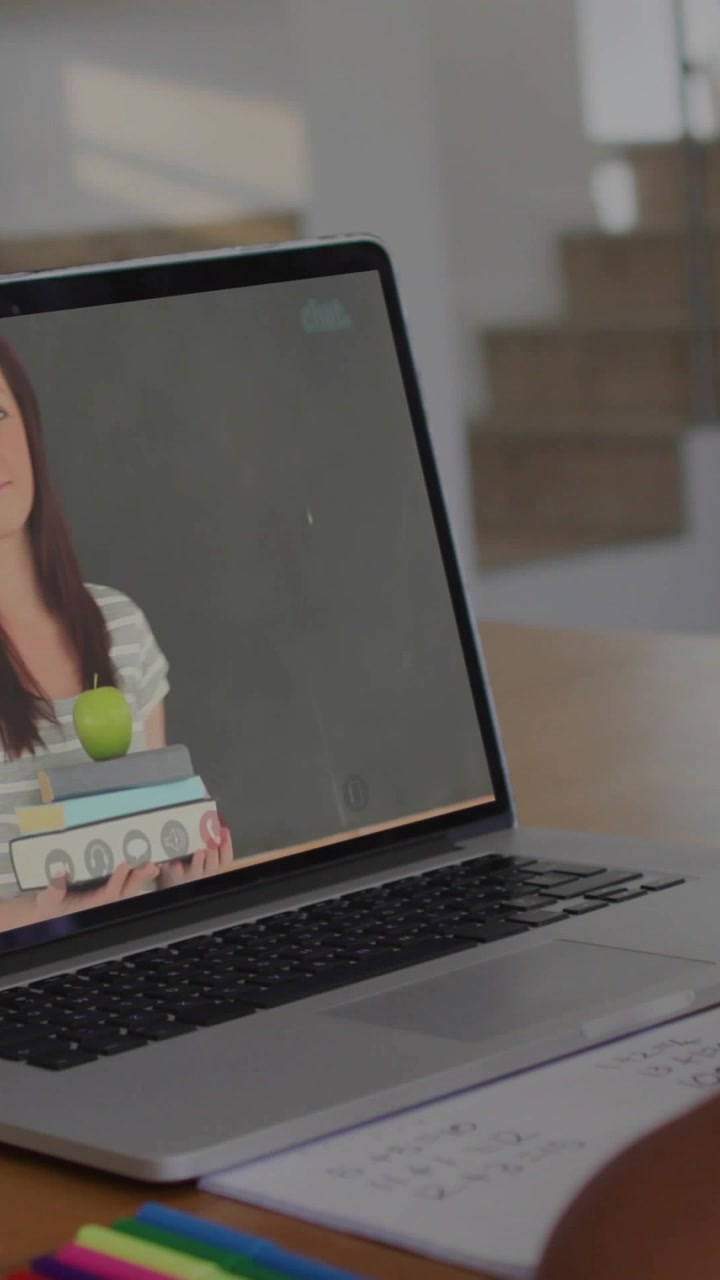 Video vertical: Mujer que aparece en laptop, barras de inicio ocultando al anfitrión, libros, manzana, enseñando a niño que mira