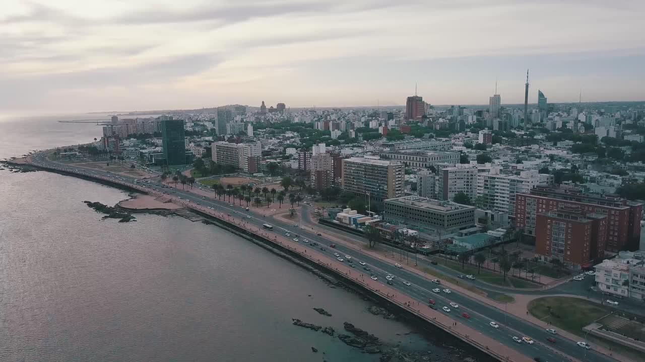 Aerial view of punta del este, uruguay, showcasing coastal road traffic, city architecture, and a cloudy sky