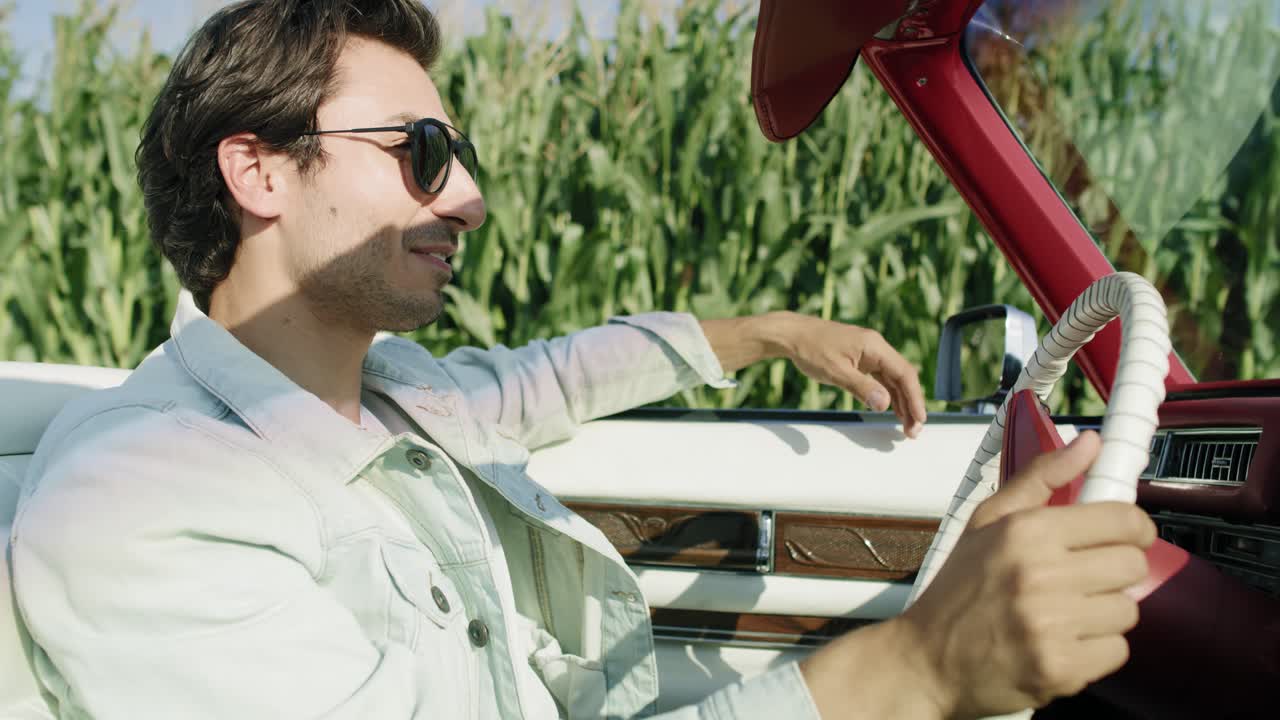 video de vista lateral de un hombre guapo conduciendo un cabriolet