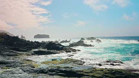 Toma-En-Cámara-Lenta-De-Olas-Del-Océano-Aplastando-Contra-La-Costa-Rocosa-Volcánica