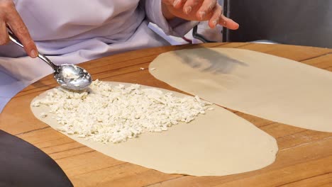 chef preparing turkish pastry with cheese filling