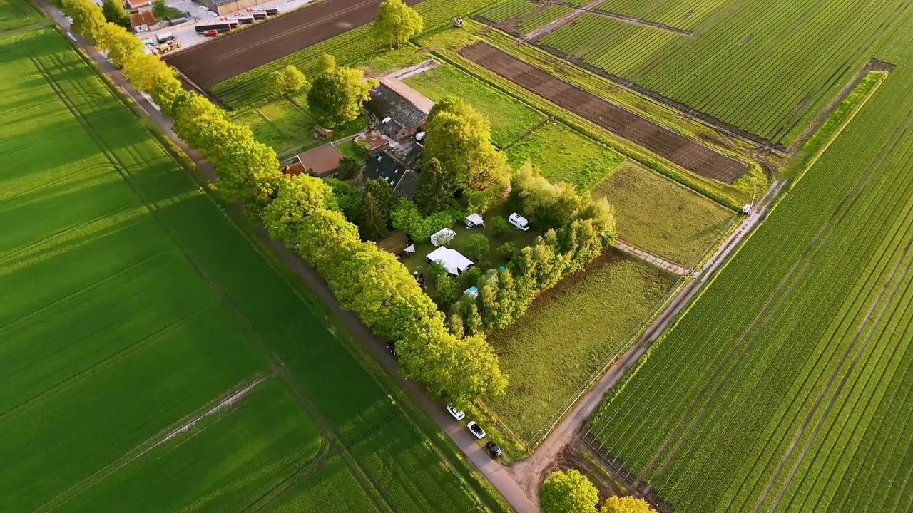 Luftfoto af en bondegård omgivet af grønne marker