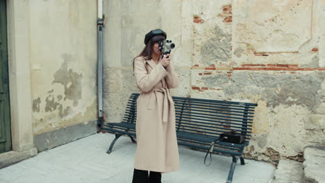 woman filming in the medieval town square with an old camera
