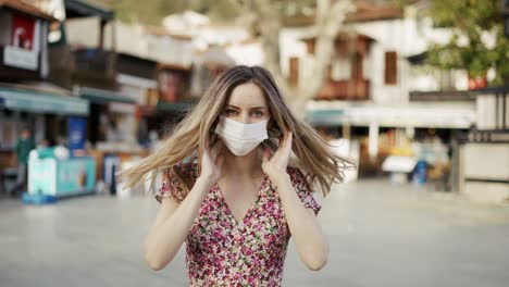 Blonde-woman-putting-on-medical-mask-for-coronavirus-protection