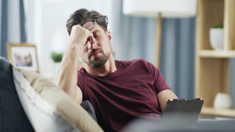 man on sofa with headache