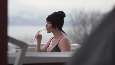 two female friends, drinking champagne, in a hot tub, in homer alaska