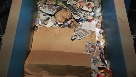 los productos de papel viajan por una cinta transportadora en un centro de reciclaje