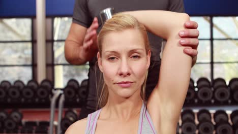 trainer helping client lift weights