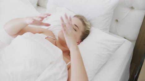 mujer caucásica cansada de talla grande tocando su cabeza en la cama en cámara lenta