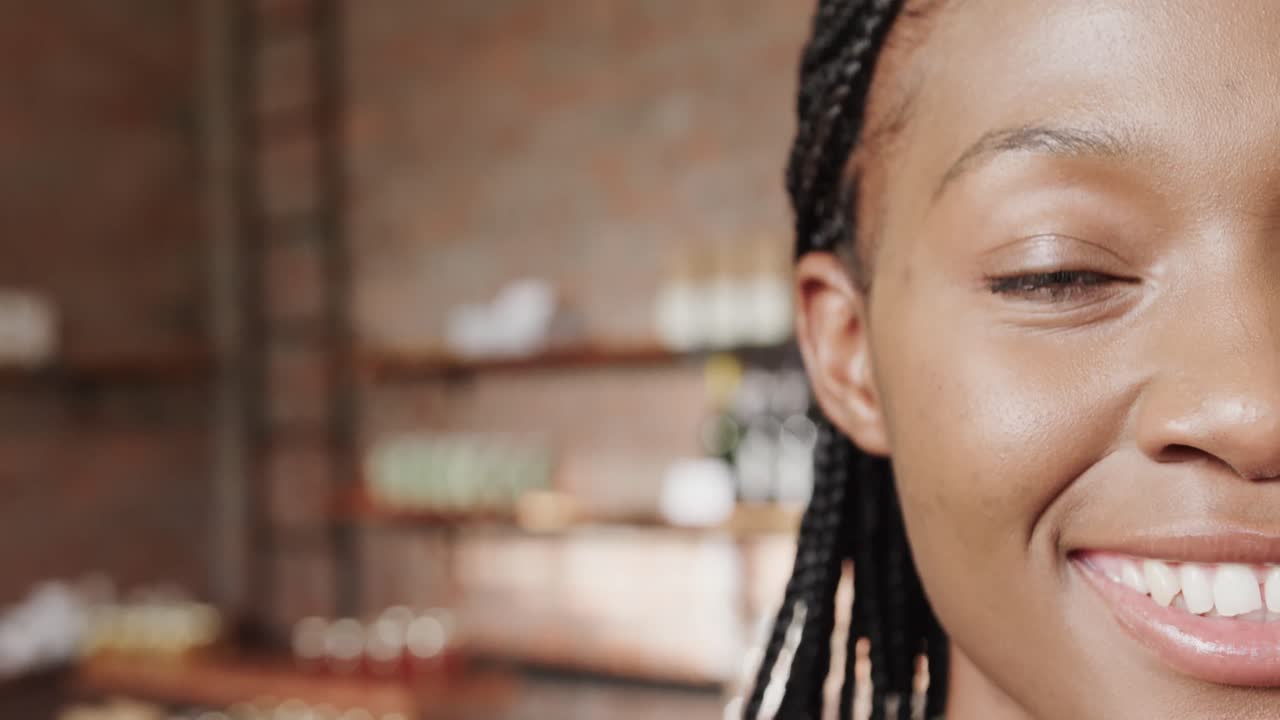 Mezzo ritratto di felice donna afroamericana che sorride in caffetteria, spazio per il testo, slow motion