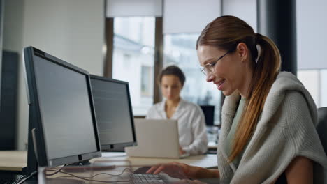 sonriendo, una mujer programando software en la oficina, un ingeniero de arranque comprobando el código.