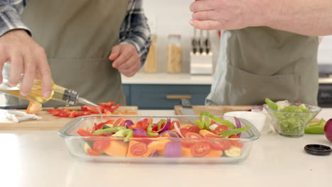 Mature couple preparing colorful vegetable dish together in modern kitchen