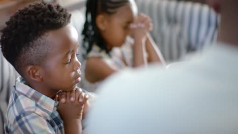 happy african american family praying before breakfast, in slow motion