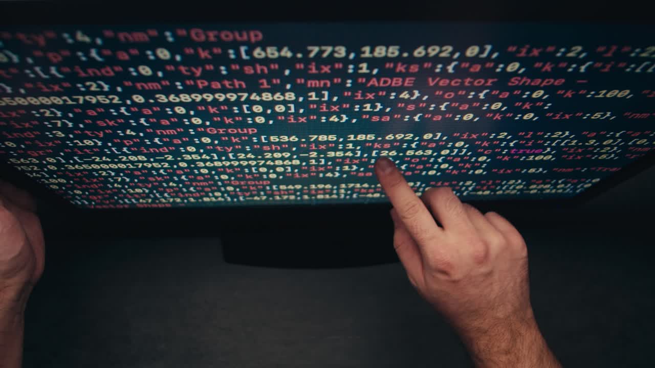 manos apuntando a un código en una pantalla de computadora