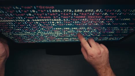 Hands pointing to code on a computer screen