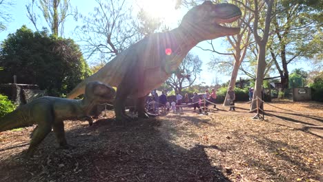 dinosaur statues in a sunny zoo setting