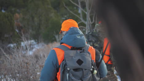 two hunters with rifles walking while observing the movement of deer in winter hunting activities