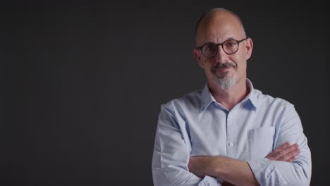 studio portrait of healthy mature man folding arms and looking into camera 1