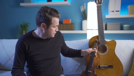 Sad-man-playing-acoustic-guitar-at-home.