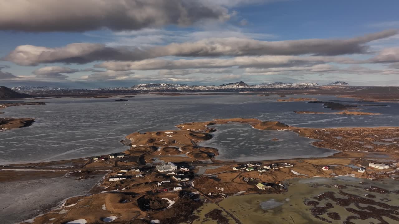 Aerial of Skútustaðir village nestled by frozen Lake Mývatn with volcanic terrain in Reykjahlíð. Iceland