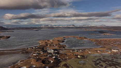 aerial of skútustaðir village nestled by frozen lake mývatn with volcanic terrain in reykjahlíð. iceland