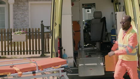 two paramedics taking medical equipment and a stretcher from the ambulance to attend a emergency 1