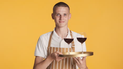 Blond-waiter-serving-two-red-wine-glasses