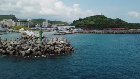 Vista-Aérea-Del-Puerto-Pesquero,-Embarcadero-De-Hormigón,-Pequeña-Torre-Del-Faro-Y-Muelle,-Norte-De-Taiwán