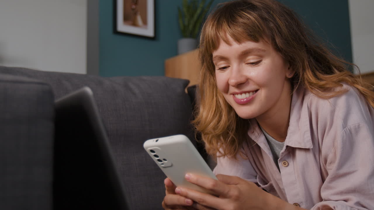 mujer usando el teléfono en el sofá