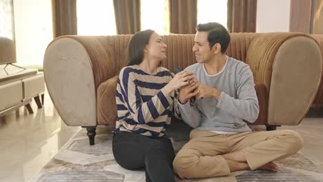 cute indian couple fighting for tv remote