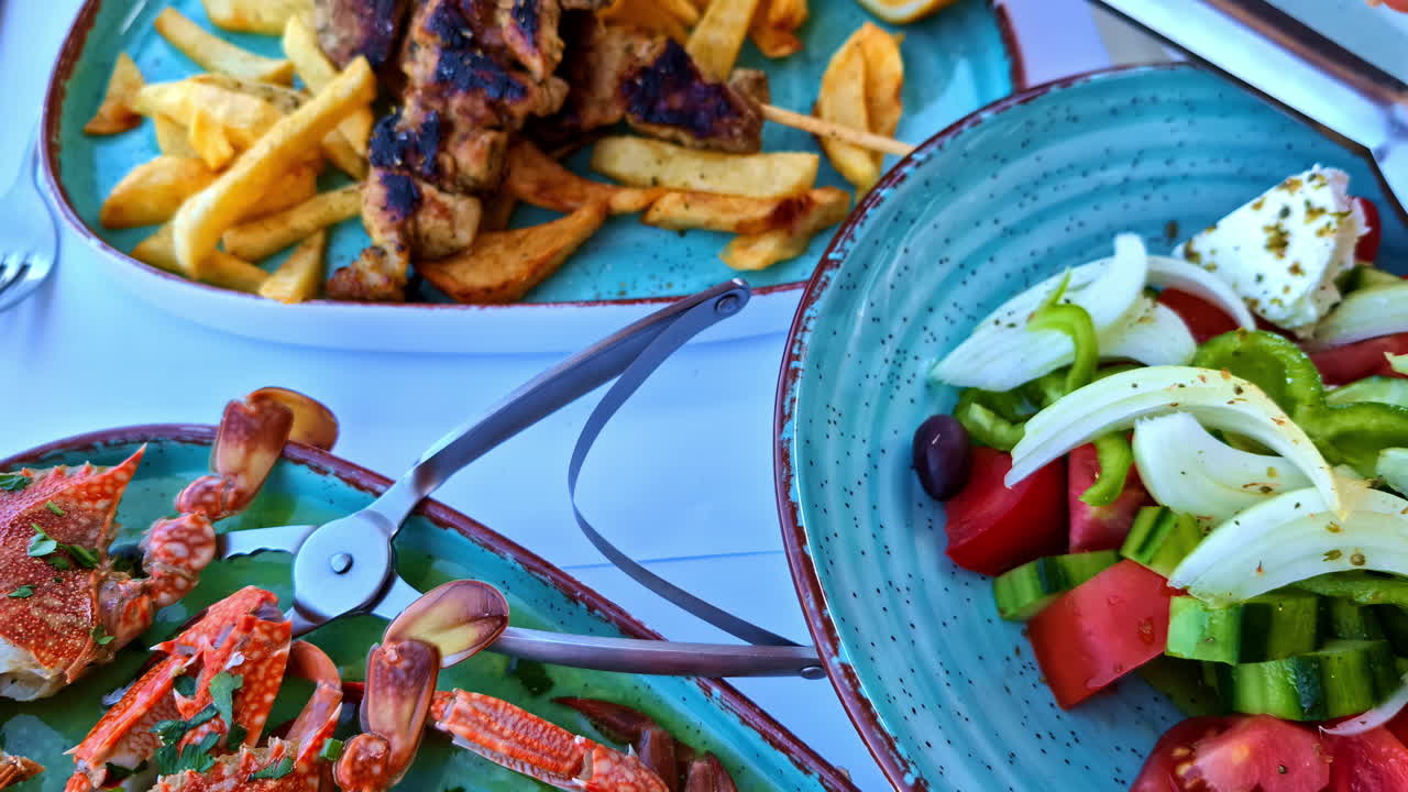 Closeup hands put pepper on a plate of Mediterranean salad with crabs, at beach restaurant