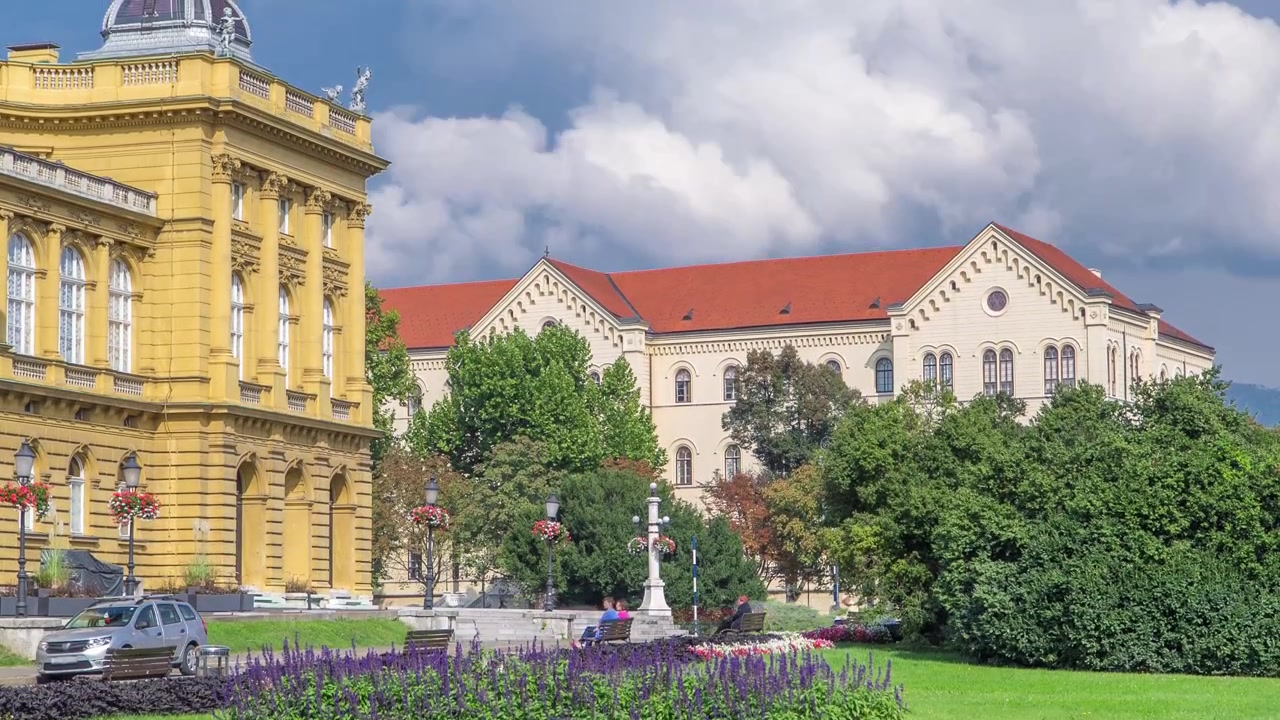 Timelapse af bygningen af det Kroatiske Nationalteater. Kroatien, Zagreb. Grøn græsplæne og blå, skyet himmel
