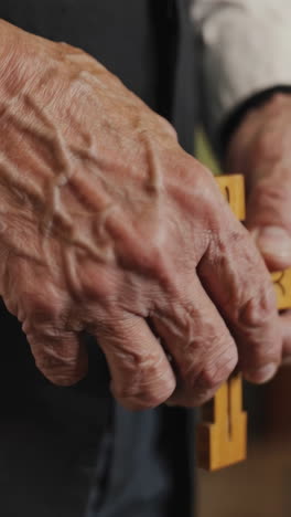 aged hands holding a wooden cross