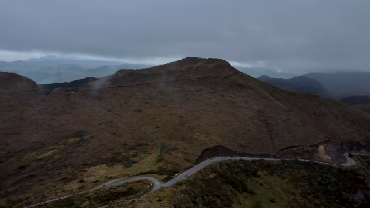 Aerial View of Winding Mountain Road on a Cloudy Day