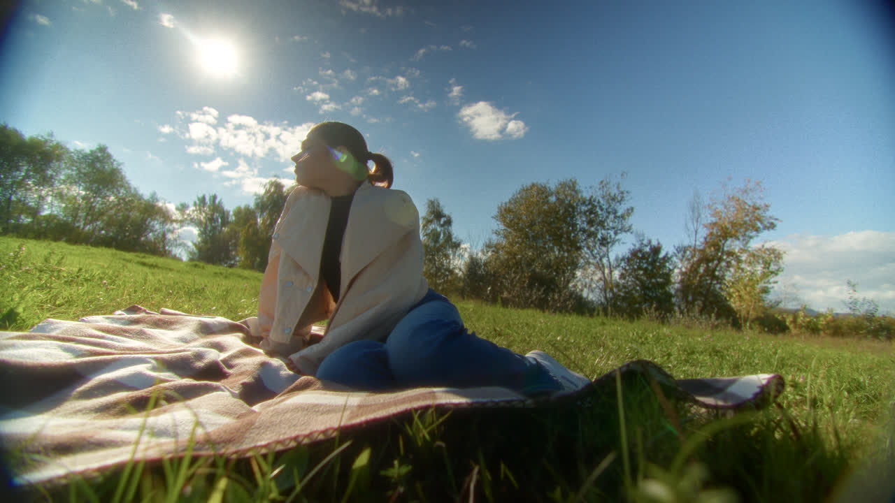 Woman relaxing on a picnic blanket in a park