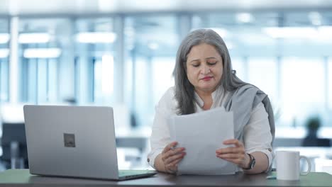 mujer gerente india feliz leyendo informes de negocios