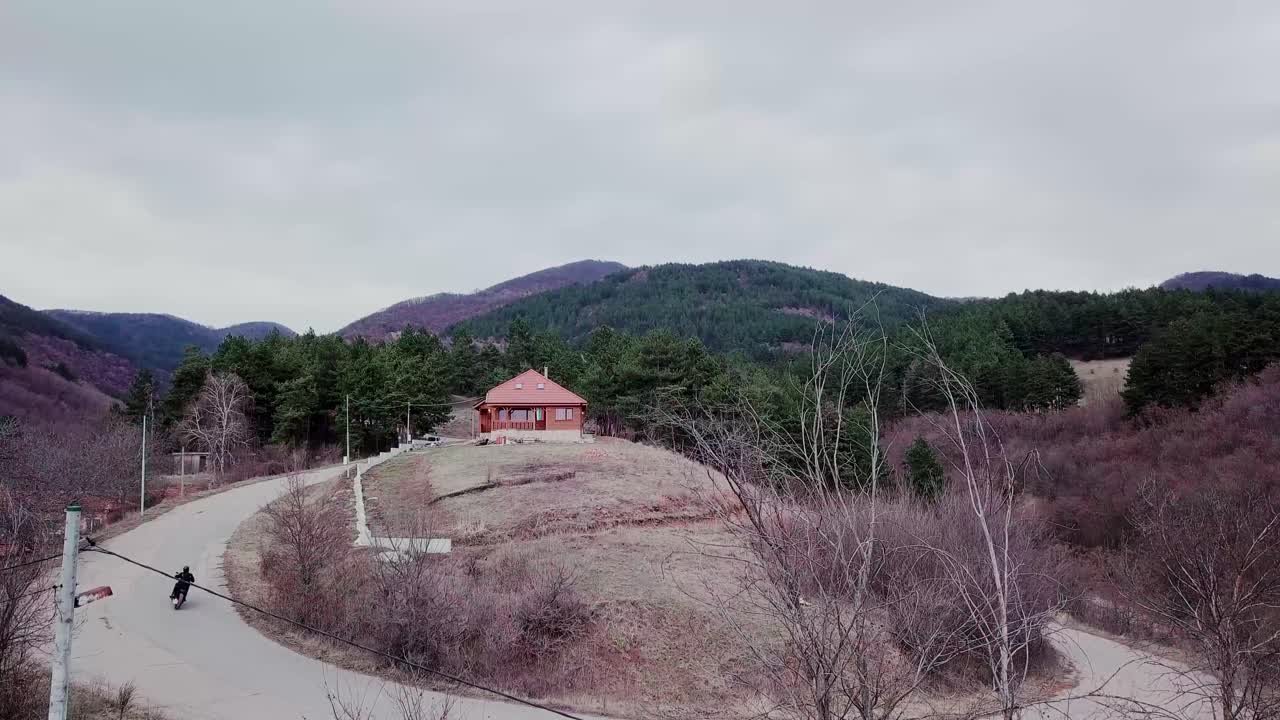 un hombre monta su motocicleta en el bosque en su camino a casa en un día nublado