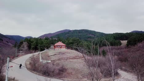 한 남자가 구름이 많은 날 집으로 가는 길에 숲에서 오토바이를 타고 있다