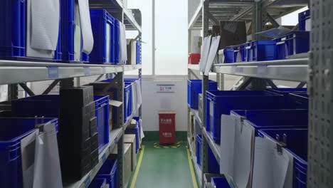 organized warehouse with blue bins and metal shelving