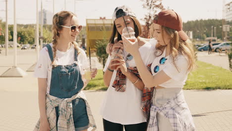 teenage girls enjoying drinks in the park