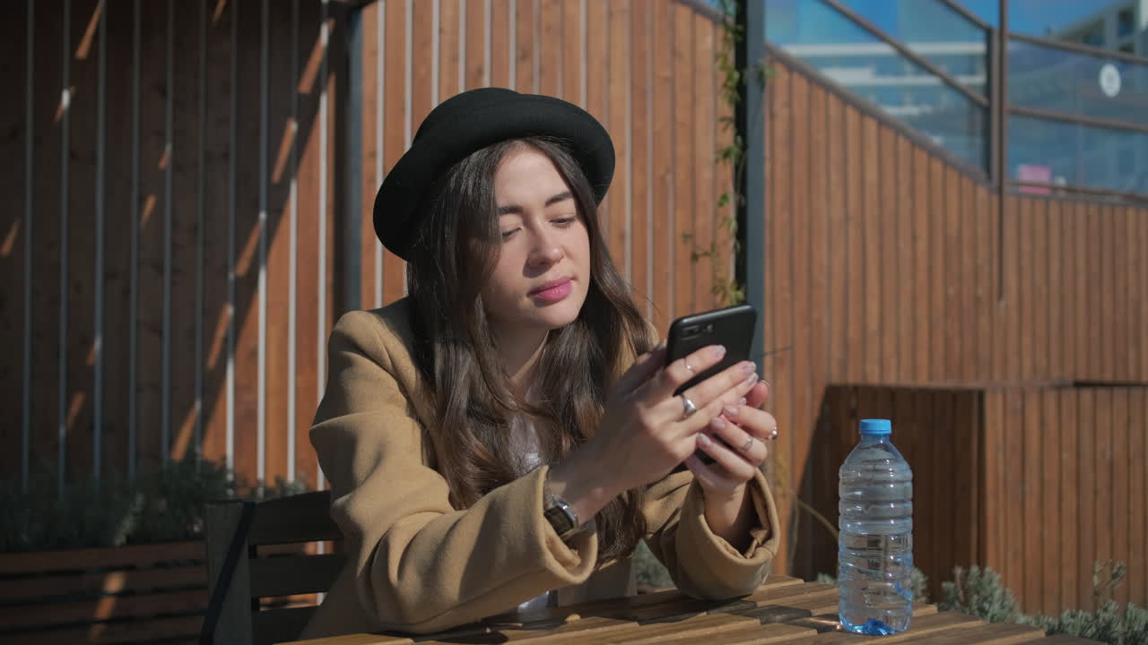 야외 카페 에서 전화 를 사용하는 여자