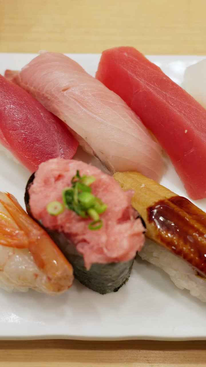 Close up of nigiri on a white plate at the Tsukiji Fish Market in Japan. Vertical