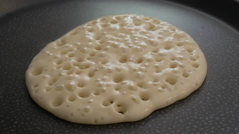 cerca de un panqueque cocinado para el desayuno con burbujas formando