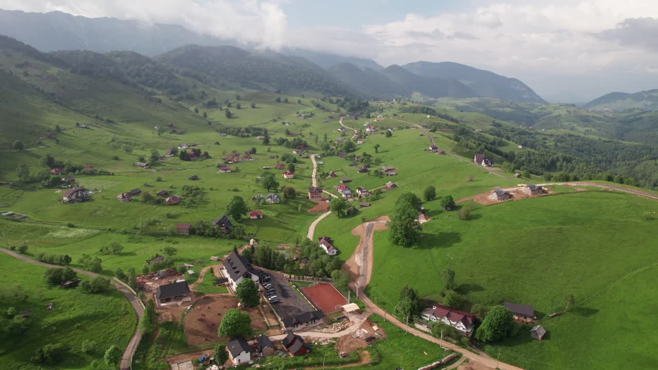 Sirnea village in romania with lush greenery, traditional houses and winding roads, summer day, aerial view