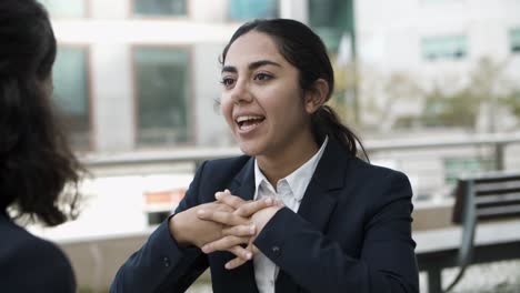mujer de negocios sonriente hablando con un colega en un café