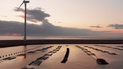 windturbines and aquaculture during sunset on the island neeltje jans, the netherlands