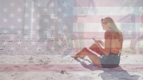 animación de la bandera de los estados unidos de américa sobre una mujer caucásica que usa un teléfono inteligente en la playa