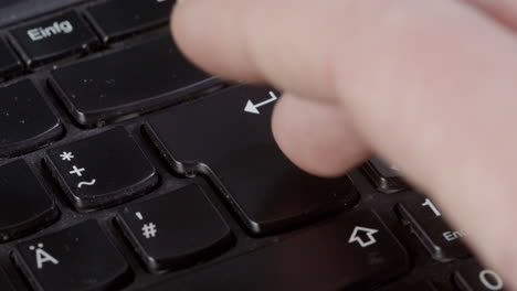 someone presses the enter key close up on a keyboard