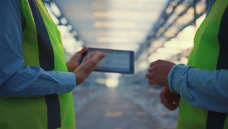 factory supervisors holding tablet checking safety level collecting information